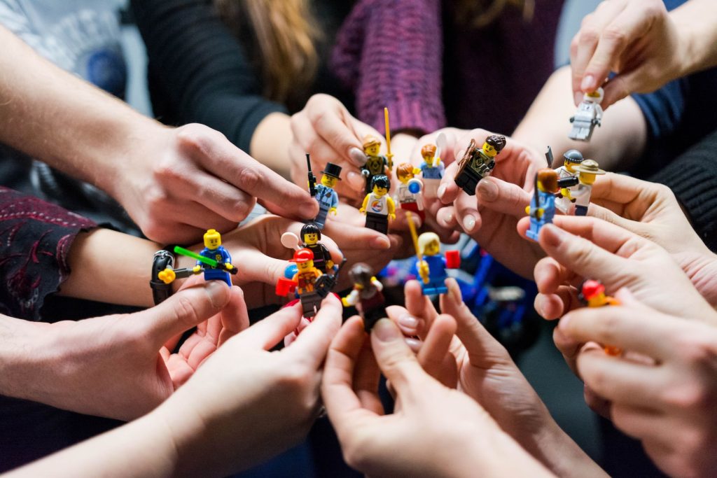 Abbildung von verschiedenen Lego Figuren welche ein diverses Team und Netzwerkstruktur darstellen. Es zeigt die Vielfalt der Teammitglieder welche bei selbstorganisierten Teams wichtig ist.