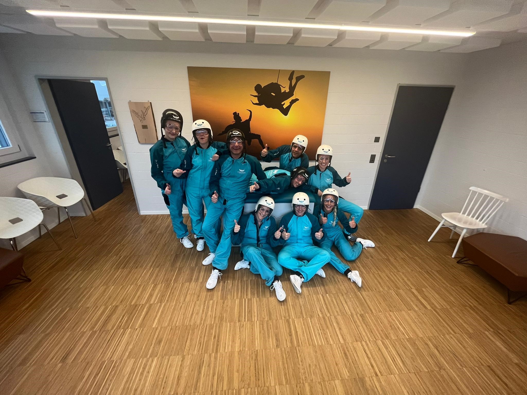 Die neun Mitarbeitenden des Pflegekaders der Schulthess Klinik wartet, ausgerüstet mit Schutzbrille, weissem Helm und türkisfarbenem Schutzanzug, auf den Start im Windkanal
