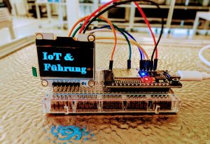 IoT-Komponenten mit Schriftzug "IoT & Führung" auf dem Display