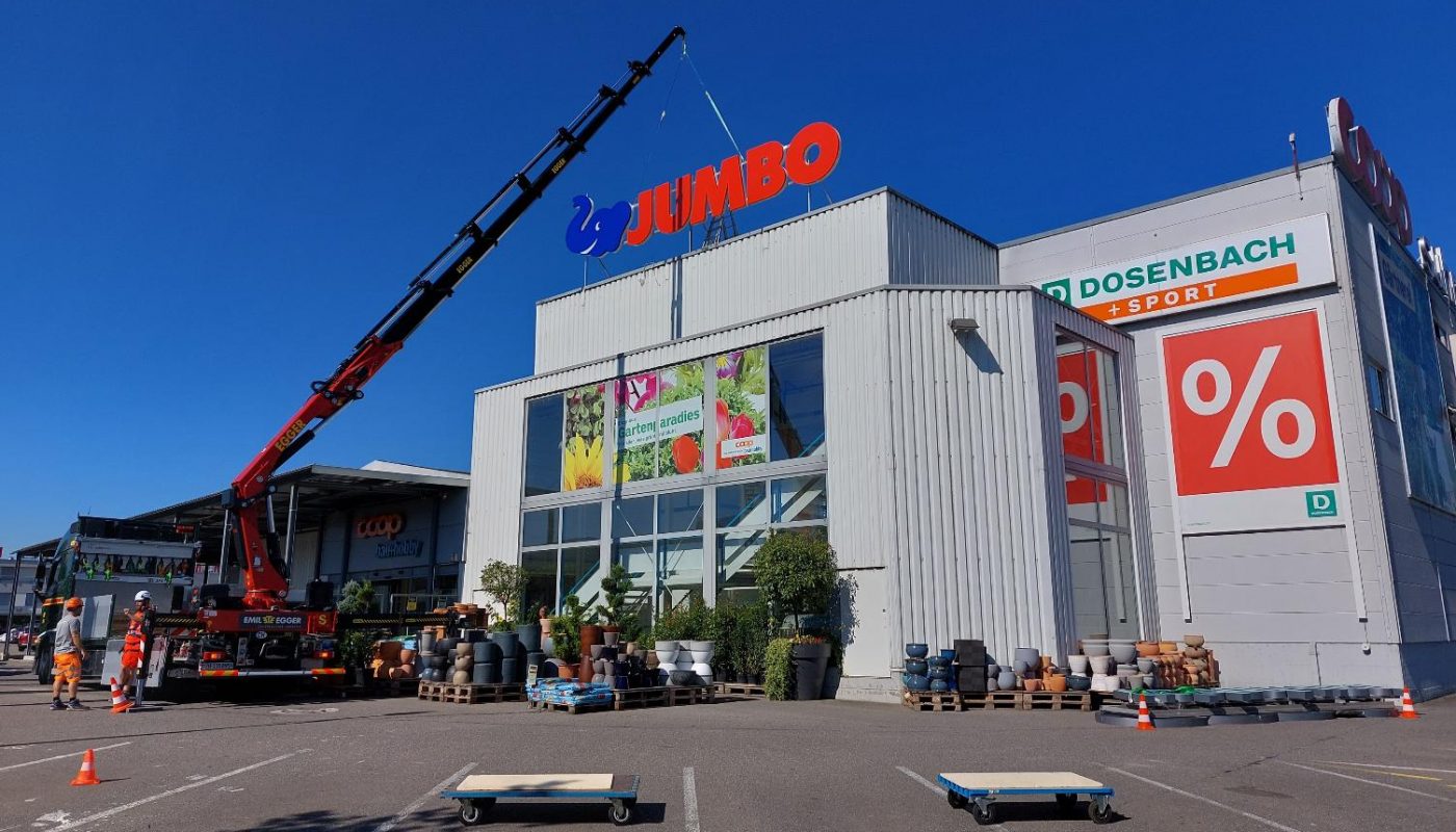 Zeigt die JUMBO Verkaufsstelle in Unterentfelden. EIn grosser Kranwagen montiert das neue JUMBO Logo