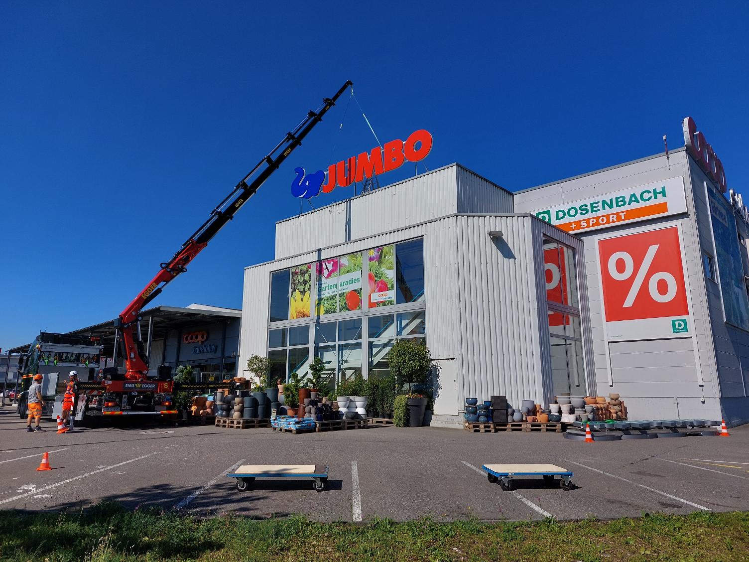 Zeigt die JUMBO Verkaufsstelle in Unterentfelden. EIn grosser Kranwagen montiert das neue JUMBO Logo