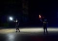 Zwei Polizisten regeln mit Stablampen den Verkehr in der Dunkelheit