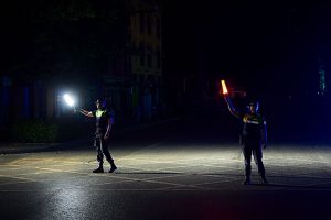 Zwei Polizisten regeln mit Stablampen den Verkehr