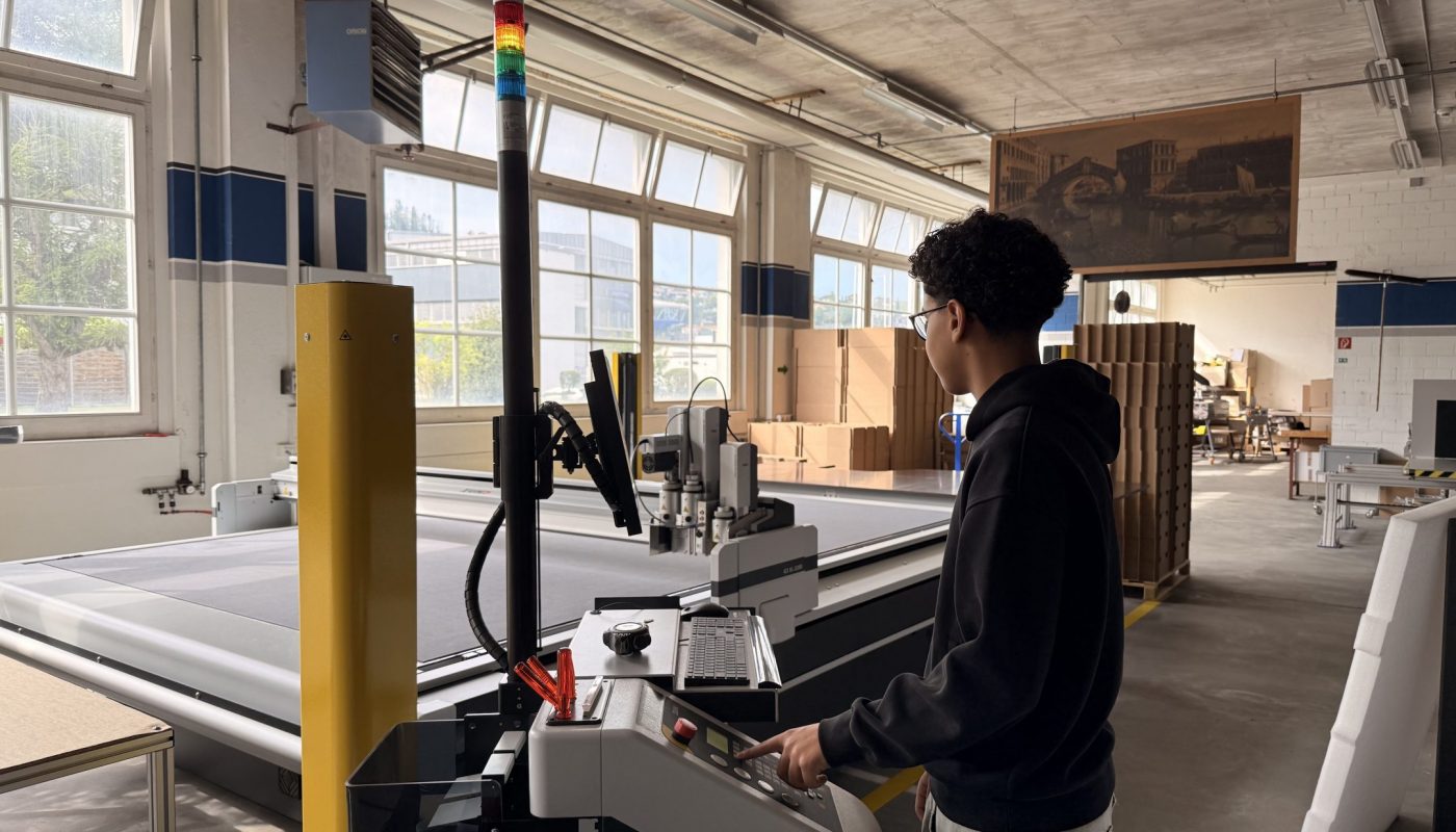 Junger Lernender arbeitet an einer Anlage in der Produktionshalle der WellPack AG