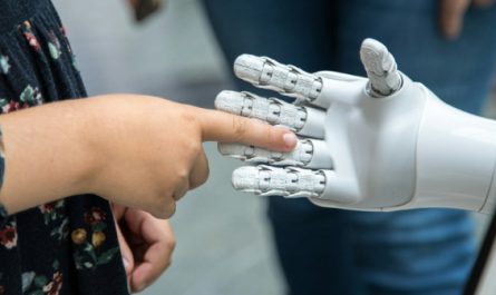 Mensch berührt eine Roboterhand.