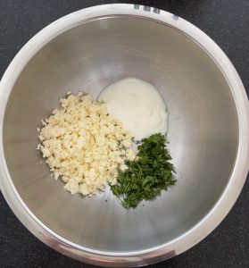 Fettarmer Hirtenkäse, Naturjoghurt und Bund Petersilie in einer Schüssel aus Chromstahl