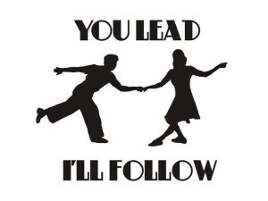 Schwarze Siluetten von einem Paar beim Tanzen, auf weissem Hintergrund steht in schwarzer fetter Schrift You lead I'll follow