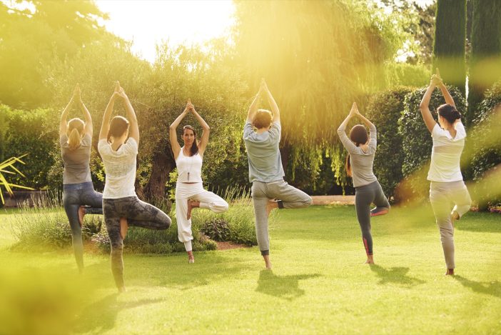 Yoga with instructor and students in the Garden of Hotel Giardino Ascona in the early morning