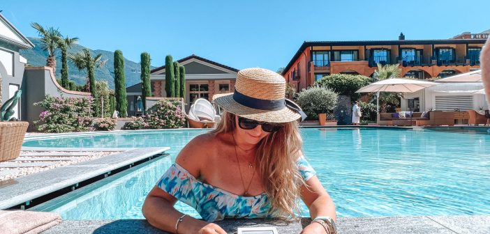 Woman in the pool reading a book at Hotel Giardino Ascona