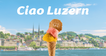 Gelato Lepore Cornetto mit gelber und rosa Kugel auf Hintergrund der Stadt Luzern