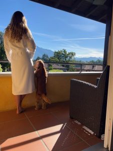 Woman standing next to her dog, a cocker spaniel. Enjoying the morning sun from their balcony.