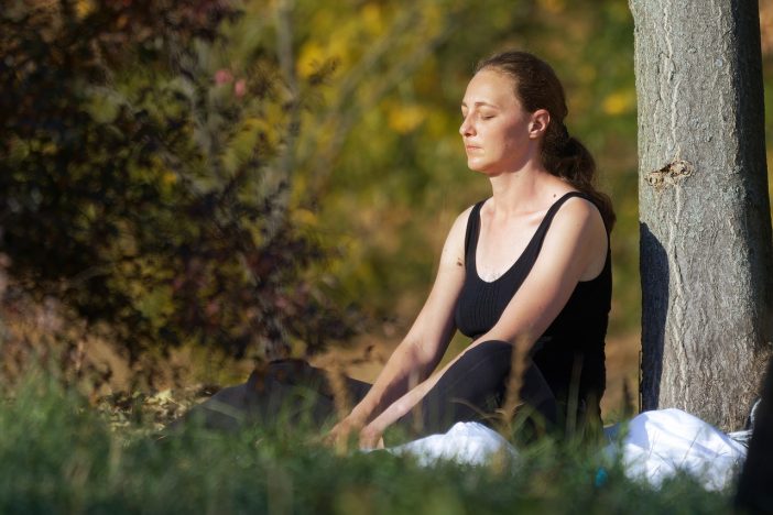 Frau meditiert im Wald