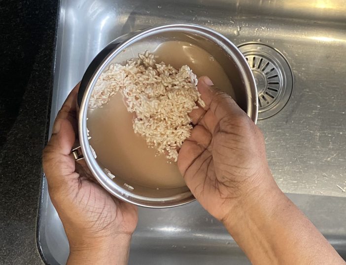 Washing the rice in a pan with water.