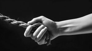 Hand einer Person die an einem Seil festhält