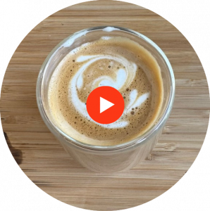 espresso with steamed milk decorated by latte art hearts and playbutton